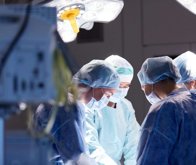 surgery, medicine and people concept - group of surgeons at operation in operating room at hospital